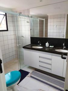 a bathroom with two sinks and a blue toilet at Lindo Apartamento na Praia do Futuro in Fortaleza