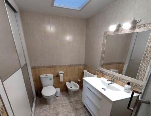 łazienka z toaletą, umywalką i lustrem w obiekcie CASA SOLEADA Piscina CLIMATIZADA y PRIVADA w mieście Santiago de la Ribera