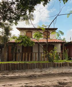 ein Haus mit einem Zaun davor in der Unterkunft Pousada Dendê Caraiva in Caraíva