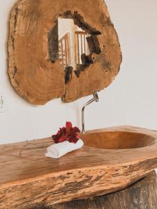 um lavatório de madeira com um espelho na parede em Pousada Dendê Caraiva em Caraíva