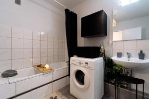 a bathroom with a washing machine and a sink at La Balastiere Metz Luxembourg Wifi Un-Séjour-à-Part in Hagondange