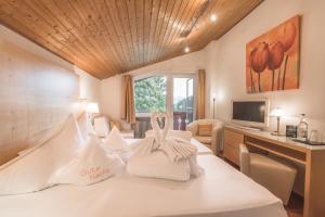 ein Hotelzimmer mit einem Bett mit zwei Kaninchen darauf in der Unterkunft Alpenhotel DAS KÜREN in Hirschegg