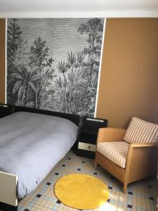 a bedroom with a bed and a couch and a chair at Charmant appartement sur cour, Le Cerisier in Bagnères-de-Bigorre