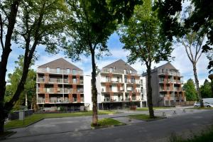 a street with two apartment buildings and trees at Apartament Green Park, Polanica Residence, garaż podziemny & mini SPA & Rowery in Polanica-Zdrój +22 photos