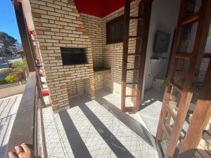 a brick building with a fireplace and a door at Residencial Parati in Bombinhas