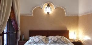 1 dormitorio con 1 cama con luz sobre ella en Riad Souad Marrakech, en Marrakech