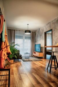 a living room with a hard wood floor and a tv at Loftowy Zakątek in Leszno