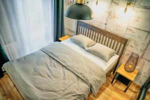 a bedroom with a bed and a lamp and a window at Loftowy Zakątek in Leszno