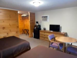 a bedroom with a bed and a table and a desk at A Holiday Motel - Maggie Valley in Maggie Valley +34 photos