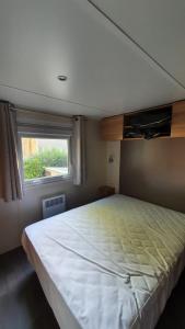 Schlafzimmer mit einem großen Bett und einem Fenster in der Unterkunft 3 chambres mimizan gastes biscarrosse camping siblu in Gastes