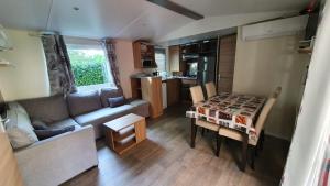 a small living room with a table and a couch at 3 chambres mimizan gastes biscarrosse camping siblu in Gastes