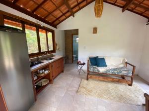 a bathroom with a sink and a couch in a room at Manacá Chalés do Vale in Vale do Capao