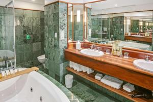 
a bathroom with a tub, sink and mirror at Shangri-La The Marina, Cairns in Cairns
