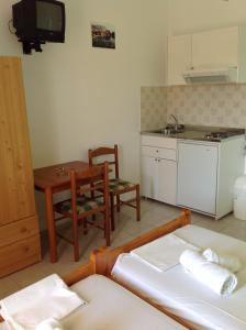ein Wohnzimmer mit einem Tisch und einer Küche in der Unterkunft Asteras Studios in Argostoli