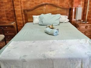 a stuffed animal is laying on a bed at Casa Blanca Tu Casa in Santa Ana