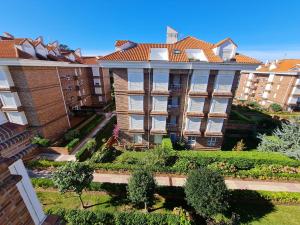 an apartment building with a garden in front of it at Noja. Piso en noja a 5 minutos de la playa de Ris in Noja