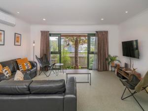 - un salon avec un canapé et une télévision dans l'établissement Manaia Magic - Tairua Holiday Home, à Tairua