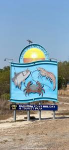 ein Schild am Strand mit einem Fisch in der Unterkunft Karumba Point Holiday & Tourist Park in Karumba