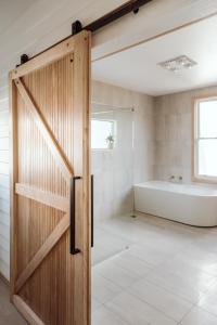 a pivot door in a bathroom with a tub and a shower at Sweet Home Alexander in Burnie