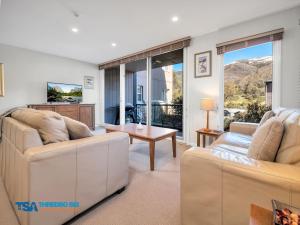 a living room with two couches and a table at Snowman 2 in Thredbo