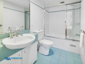 a white bathroom with a sink and a toilet at Snowman 2 in Thredbo +7 photos