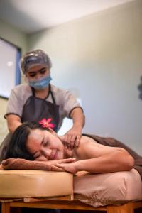 a woman laying on a bed with a masseur at Royal Regantris Trawangan in Gili Trawangan