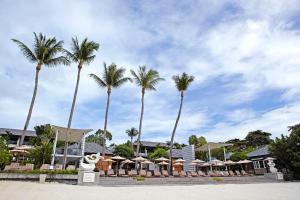 eine Reihe von Palmen und Sonnenschirmen am Strand in der Unterkunft Sareeraya Villas & Suites in Chaweng