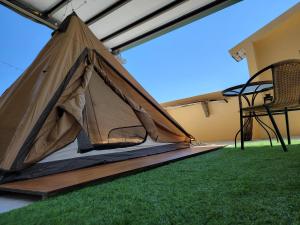 a tent on a lawn with a chair at Dulan Groundnut Backpacker Hostel in Donghe