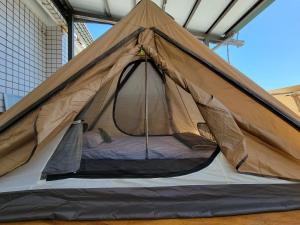 uma tenda com uma cama dentro dela em Dulan Groundnut Backpacker Hostel em Donghe