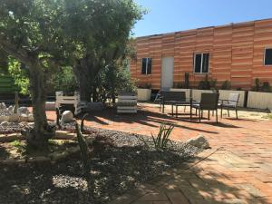 un patio con sillas, un árbol y un edificio en Susu’Z Village Hostel and Rooms, en La Ventana