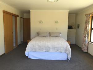 a bedroom with a white bed and a window at Baton Country Escape in Thorpe +7 photos