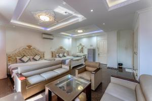 uma sala de estar com uma cama, um sofá e uma mesa em Happy Land Hotel em Ho Chi Minh