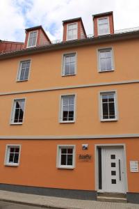 un edificio naranja con ventanas blancas en Apartments Rudolstadt en Rudolstadt