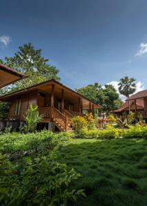 une maison en bois avec une pelouse devant elle dans l'établissement Casa Kandara, à Waingapu