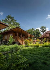 a wooden house with a lawn in front of it at Casa Kandara in Waingapu