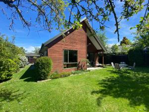 a small house with a grassy yard in front of it at 18c Scarborough Tce in Hanmer Springs
