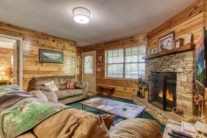 a living room with a couch and a fireplace at Sunset Ridge Cabin in Pigeon Forge