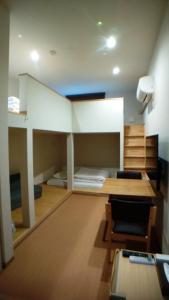 a large room with a bunk bed and a desk at Hiroshima Saijo Youth Hostel in Higashihiroshima