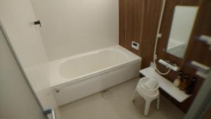 a bathroom with a white tub and a sink at Hiroshima Saijo Youth Hostel in Higashihiroshima +35 photos