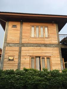 a wooden house with two windows on the side of it at The Pud dee in Chiang Khan