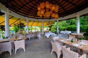 バンペーにあるBarong Resortのテーブルと椅子、シャンデリアのあるレストラン