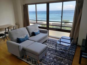 uma sala de estar com um sofá e vista para o oceano em HOTEL&RESORT Izu no Ne em Higashiizu