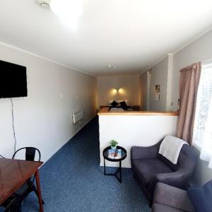 a living room with a couch and a table at Chanel Court Motel in Masterton
