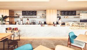 a bar in a restaurant with people standing behind the counter at ANA InterContinental Ishigaki Resort, an IHG Hotel in Ishigaki Island