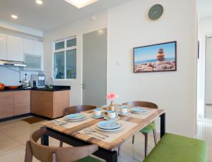 a kitchen and dining room with a wooden table and chairs at Seaview condo near RF Mall, Food Court & Free Netflix in Johor Bahru