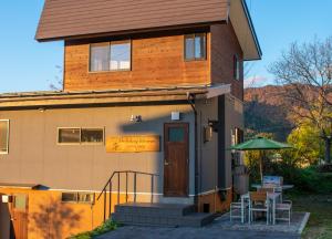 a house with a porch and a table and chairs at Holiday Home Nozawa in Nozawa Onsen
