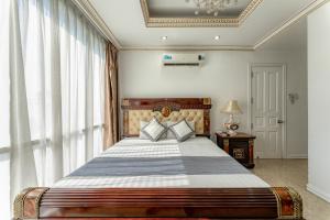 um quarto com uma cama grande e uma janela grande em Happy Land Hotel em Ho Chi Minh