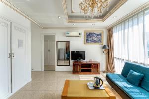 uma sala de estar com um sofá azul e uma televisão em Happy Land Hotel em Ho Chi Minh