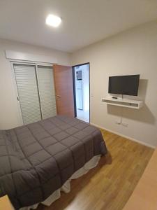 1 dormitorio con 1 cama y TV de pantalla plana en Vittoria en Victoria