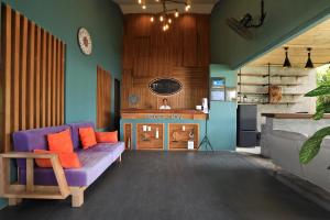 een woonkamer met een paarse bank en een open haard bij Tea Tree Boutique Resort in Rawai Beach